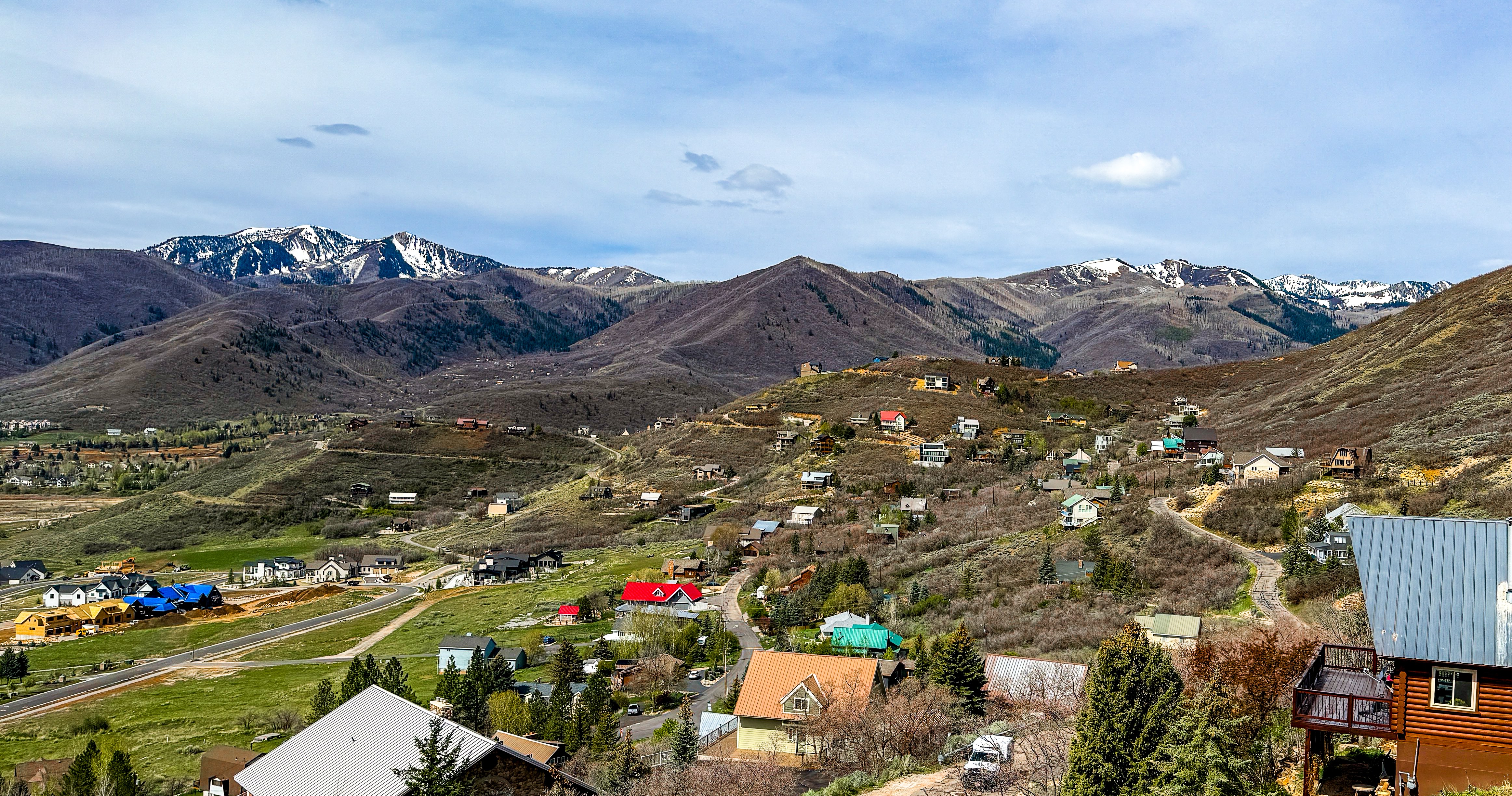 Interlaken hillside community in Midway Utah with custom homes stepping up the bench and snow-capped Wasatch Range in the background