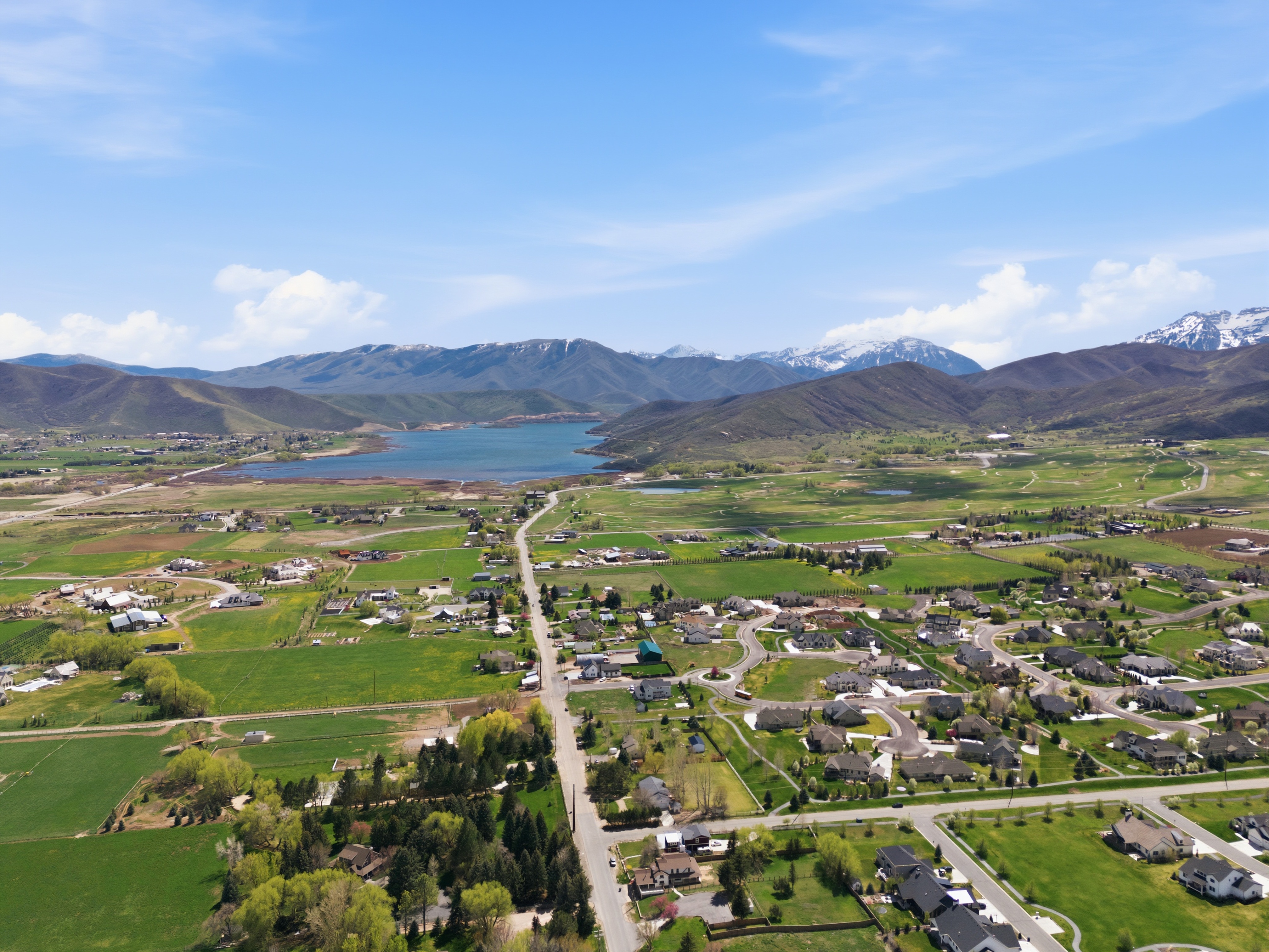 Aerial view of Midway Utah with Deer Creek Reservoir and Wasatch mountains, luxury homes and acreage in foreground