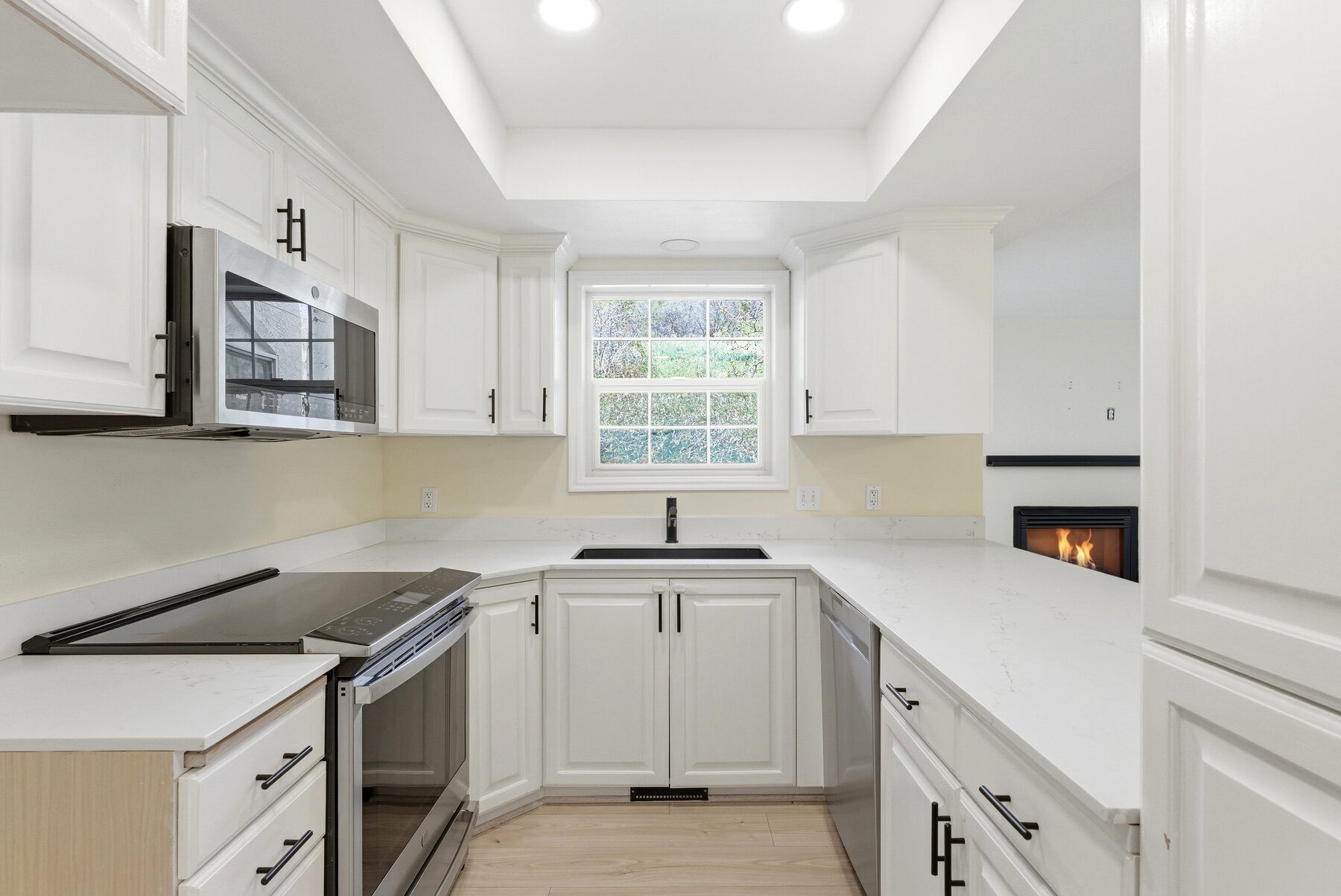 Updated kitchen with stainless appliances and white cabinetry in Swiss Oaks Midway condo