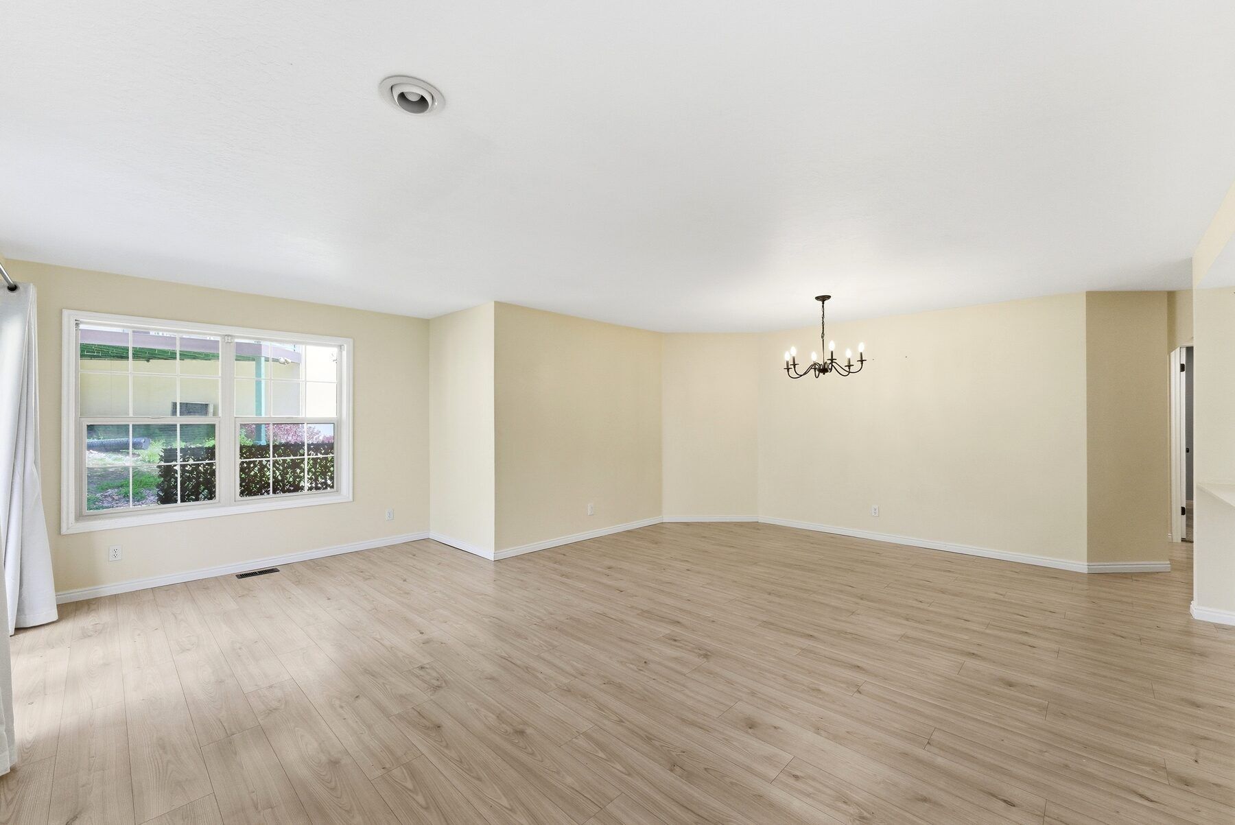 Bright living room with large windows in single-level Swiss Oaks condo Midway