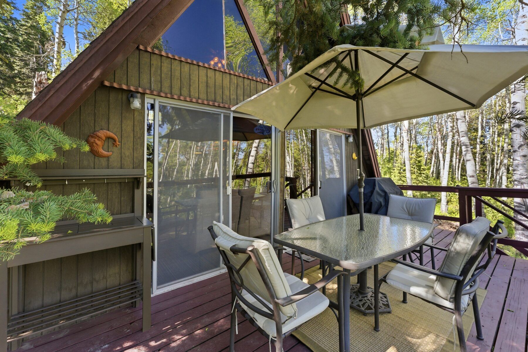 Outdoor dining on the back deck surrounded by forest at 11106 E Green Briar Heber City