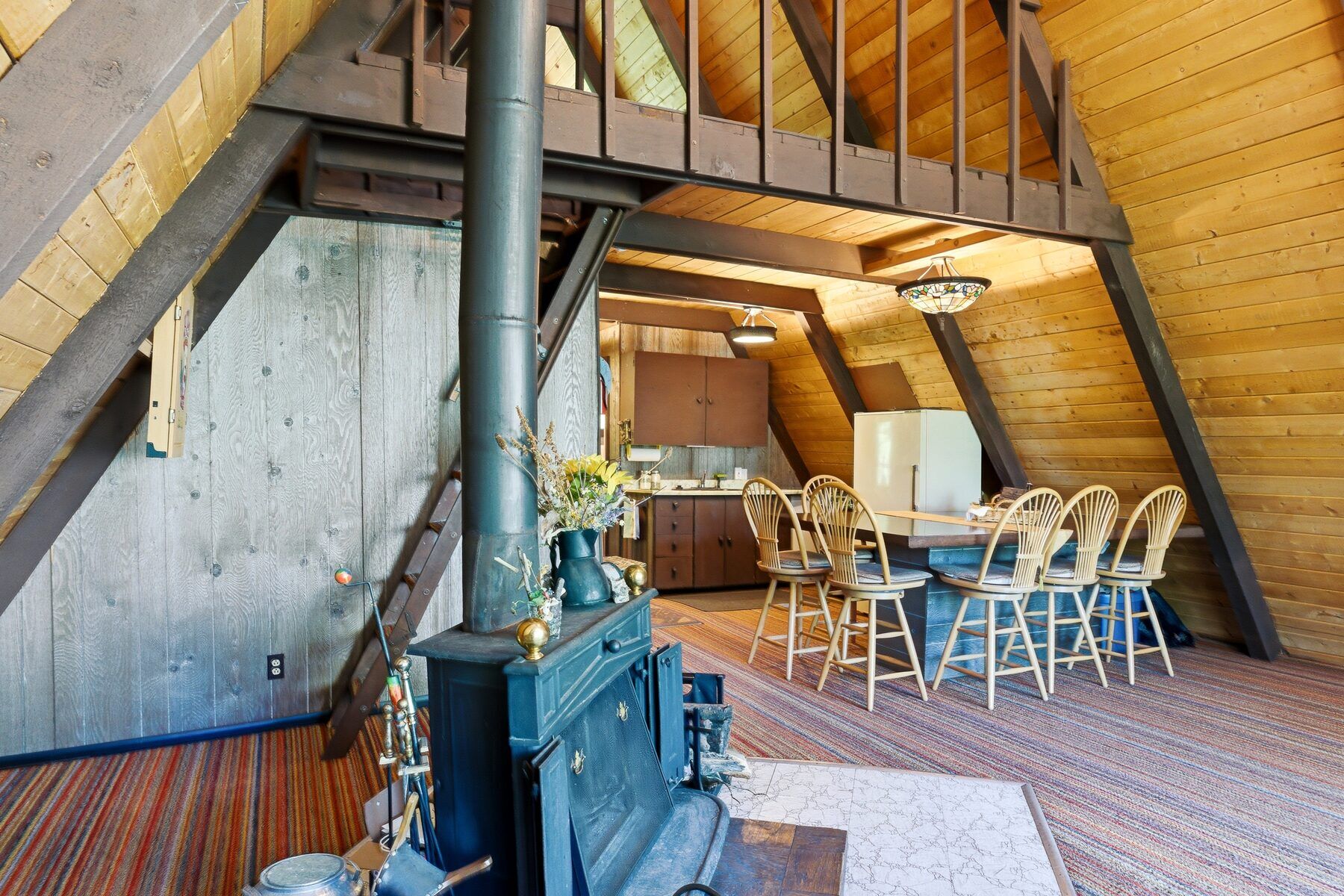 Open vaulted great room in Heber City cabin with wood ceilings and loft above
